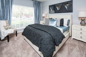 Lawrenceville apartment for rent - A bedroom with a large bed and a window with blinds.