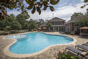 Lawrenceville apartment for rent - A large outdoor swimming pool surrounded by lounge chairs and trees.