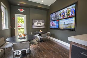 Lawrenceville apartment for rent - A dining room with a table set for two and a wall of television screens.