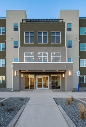 Rio Rancho apartment for rent - A modern apartment building with a flat roof and a large glass entrance.