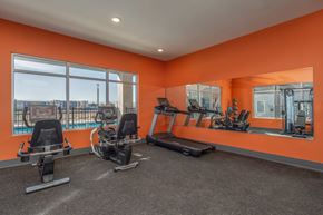 Rio Rancho apartment for rent - A gym with orange walls and a view of the city.