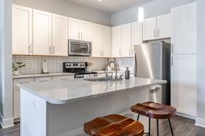 Chattanooga apartment for rent - A kitchen with white cabinets and a marble countertop.