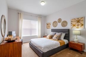 Independence apartment for rent - a bedroom with a bed and a dresser and a window