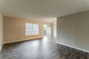 Beaverton apartment for rent - the living room and dining room of an empty home with wood flooring