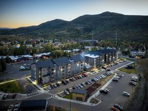Steamboat Springs apartment for rent - A parking lot with cars and apartment buildings in the background.