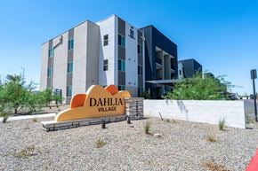 Phoenix apartment for rent - A modern building with the name Dahlia Village on a sign in front of it.