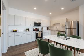 Phoenix apartment for rent - A kitchen with white cabinets and a marble table.