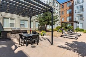 Denver apartment for rent - a patio with a table and chairs in front of an apartment building