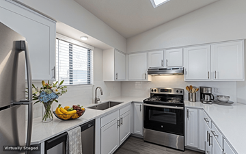 Westminster townhouse for rent - A kitchen with a stainless steel refrigerator, a sink, and a stove top oven.
