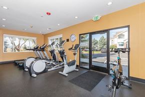 Littleton apartment for rent - A gym with a row of exercise bikes and a clock on the wall.