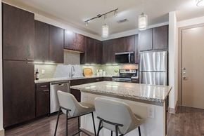 San Antonio apartment for rent - A kitchen with brown cabinets and a granite countertop.