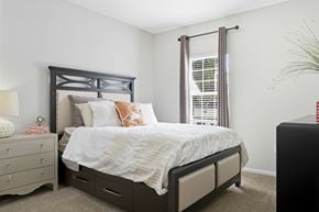 Overland Park apartment for rent - A bedroom with a large bed and a nightstand with a lamp.