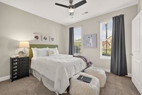 Gallatin apartment for rent - A bedroom with two beds, a ceiling fan, and a window with blinds.