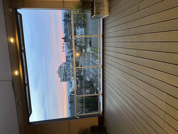 Vancouver apartment for rent - A view of a cityscape through a window with a wooden wall on the side.