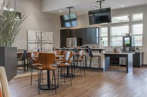 Phoenix apartment for rent - a clubhouse with tables and chairs and a kitchen with a tv