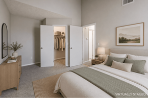 Northglenn apartment for rent - A bedroom with a large bed, a dresser, and a mirror.