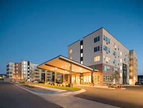 Northglenn apartment for rent - A modern building with a parking lot in front.