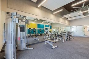 Northglenn apartment for rent - a gym with cardio equipment and weights on the floor