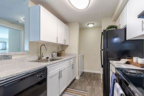 Frederick apartment for rent - a kitchen with white cabinets and black appliances