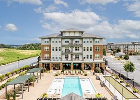 Fredericksburg apartment for rent - A large building with a pool in front.