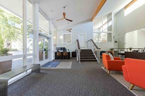 Tacoma apartment for rent - A modern office space with orange chairs and a staircase.