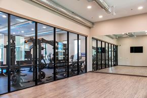 Reno apartment for rent - A gym with a mirrored wall and wooden floors.