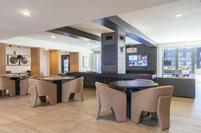 Kansas City apartment for rent - A modern dining room with a black table surrounded by tan chairs.