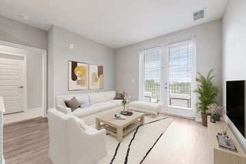 Tampa apartment for rent - A living room with a white couch, a coffee table, and a painting on the wall.