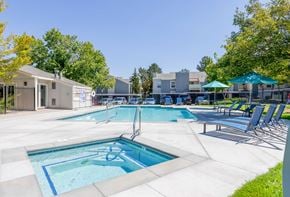 Reno apartment for rent - A large outdoor swimming pool with a slide and sun loungers.