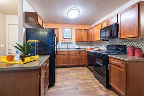 Salt Lake City apartment for rent - a kitchen with black appliances and wooden cabinets