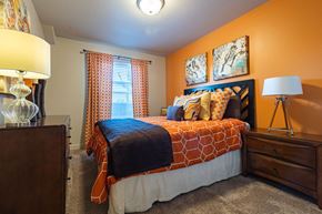 Salt Lake City apartment for rent - bedroom with orange walls and a bed with orange and white comforter