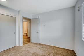 Tigard apartment for rent - a bedroom with white walls and a door to a bathroom