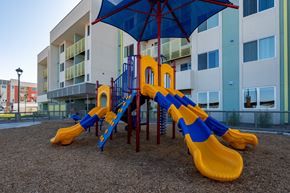 Maricopa apartment for rent - A playground with a blue umbrella and yellow slides.