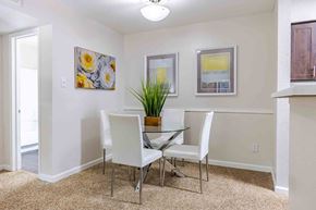 Austin apartment for rent - A dining room with a glass table and white chairs.