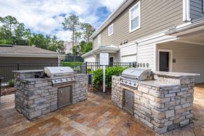 Orlando apartment for rent - Two stone BBQs are in a courtyard in front of a house.