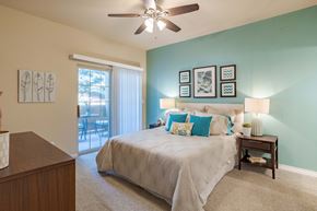 Colorado Springs apartment for rent - a bedroom with a large bed and a ceiling fan