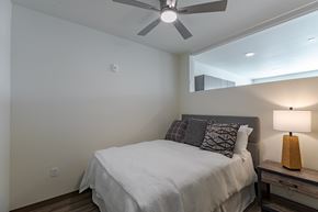 Aurora apartment for rent - A bedroom with a bed, nightstand, and a ceiling fan.