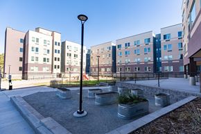 Aurora apartment for rent - A modern building complex with a courtyard and planters.