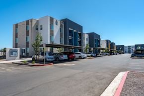 Phoenix apartment for rent - A parking lot in front of a modern building with cars parked.
