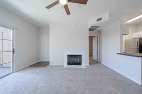 Phoenix apartment for rent - A living room with a fireplace and a ceiling fan.
