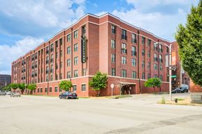 St Louis apartment for rent - A red brick building with a parking lot in front.