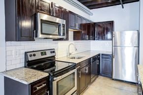 St Louis apartment for rent - A kitchen with dark brown cabinets and stainless steel appliances.