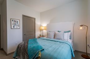 Murfreesboro apartment for rent - A bedroom with a bed covered in a blue blanket.