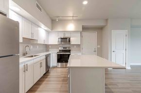 Loveland apartment for rent - a kitchen with white cabinets and stainless steel appliances