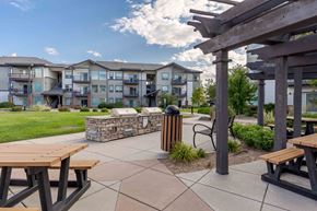 Loveland apartment for rent - clubhouse with picnic tables and a fire pit with an apartment building in the background