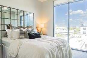 Nashville apartment for rent - A bedroom with a large bed and a view of the city.