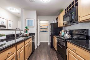 Frederick apartment for rent - a kitchen with black appliances and wooden cabinets