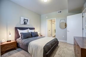 Ft Collins apartment for rent - A bedroom with a bed, nightstand, and a mirror on the wall.