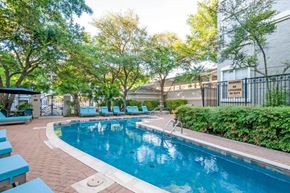 San Antonio apartment for rent - a swimming pool with chairs and a building in the background