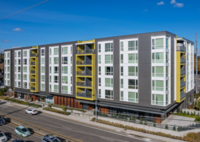 Hillsboro apartment for rent - A modern multi-story building with a mix of grey, yellow, and white sections.